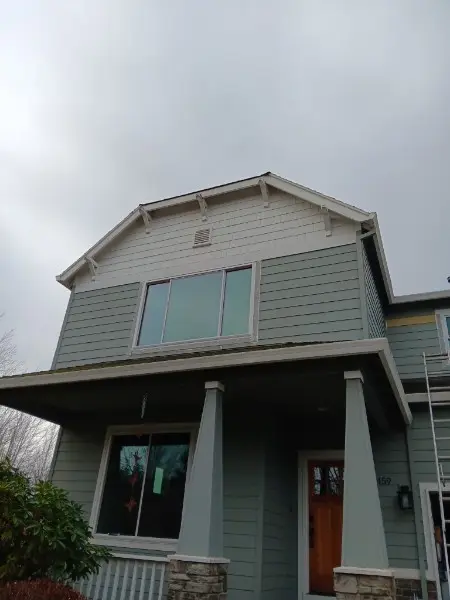 New upper-story picture window on a green craftsman two-story with a covered porch